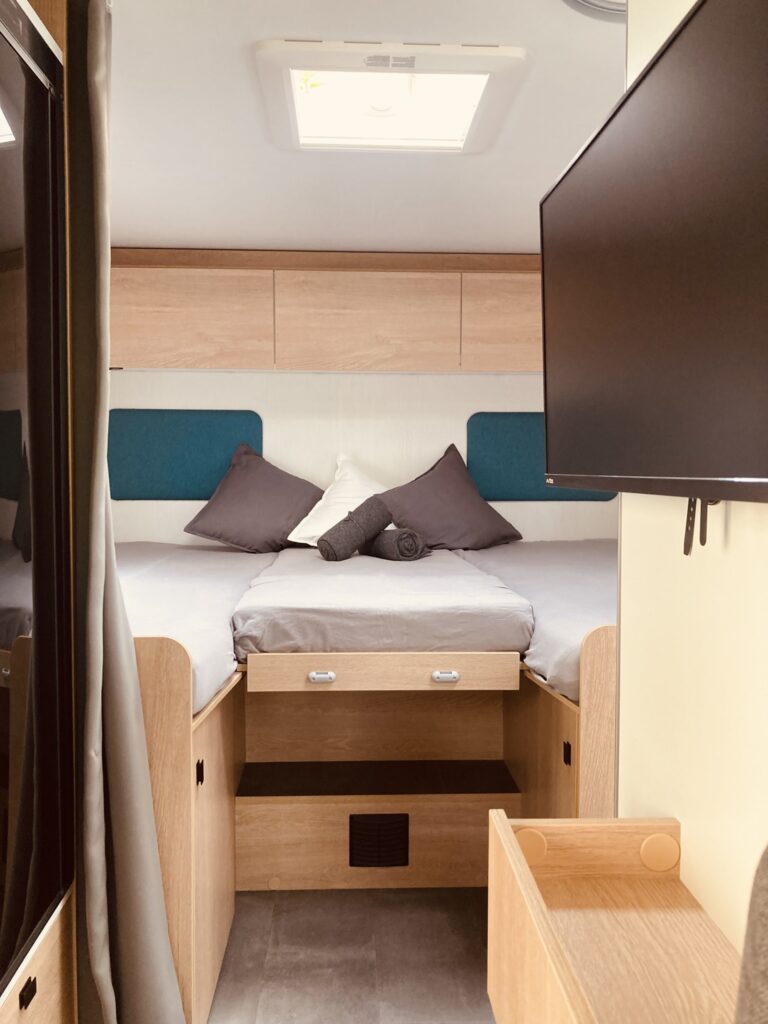 Gemütliches großes Bett mit Vorhang im Wohnmobil mit Platz für 2 bis 3 Personen